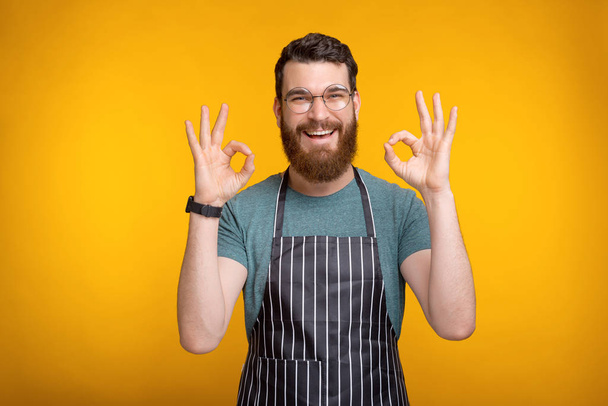 Photo of cheerful young chef guy in uniform showing OK gesture - Photo, Image