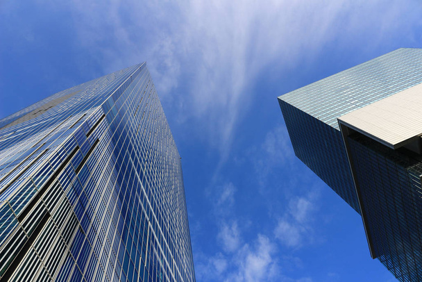 Paysage de deux gratte-ciel avec des conceptions différentes debout sous le ciel bleu
 - Photo, image