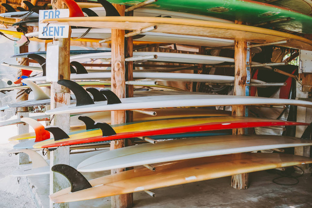 Барвисті дошки для серфінгу в магазині для оренди на пляжі. водне спортивне обладнання. вінтажний кольоровий тон ефект
.  - Фото, зображення