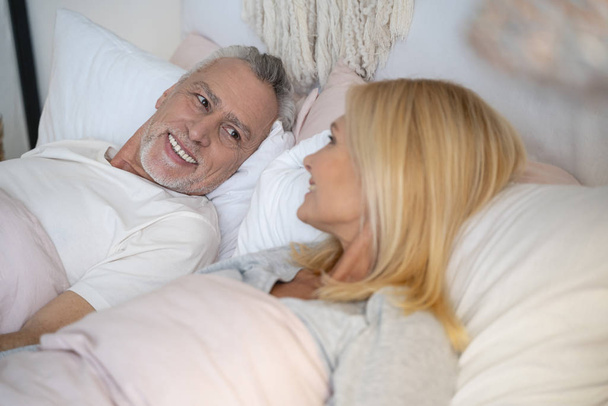 Mirthful man and woman in bed stock photo - Photo, image