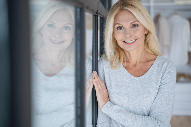 Happy smiling lady by the window stock photo - Foto, Imagen
