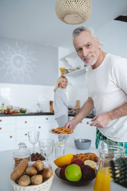 Smiling man near the table with tasty food stock photo - Foto, afbeelding