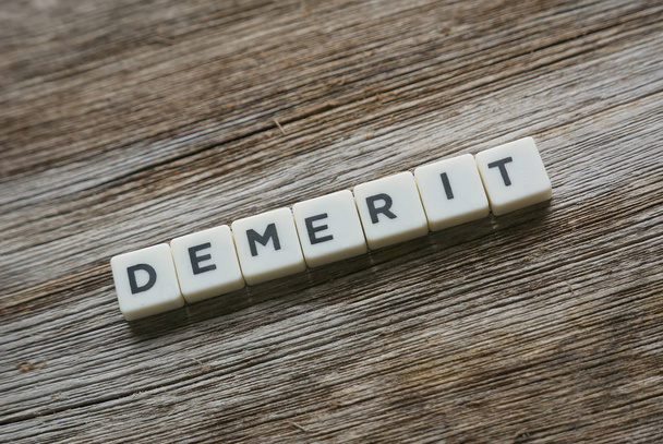 Demerit in alphabet on wooden background. - Foto, Imagen