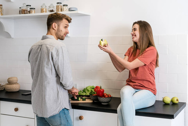 Fiatal felnőtt nő és férfi töltik reggel a konyhában - Fotó, kép