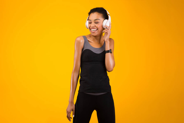 Vreugdevolle Afrikaanse Amerikaanse vrouw Luisteren naar muziek, Studio Shot - Foto, afbeelding