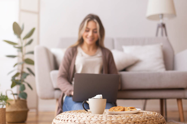 Cup of coffee and cookies waiting for adorable girl with laptop - Photo, Image