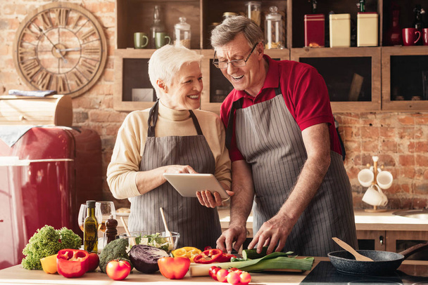 Χαρούμενοι παππούδες που διαβάζουν εξωτικές συνταγές σε ψηφιακό tablet - Φωτογραφία, εικόνα