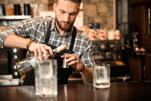 Bearded barman is making alcoholic cocktail at bar - Foto, immagini