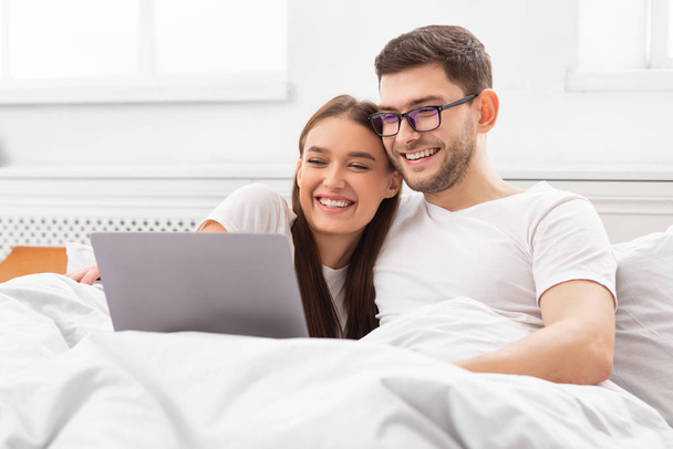 Para oglądać film na laptopie siedzi w łóżku w domu - Zdjęcie, obraz