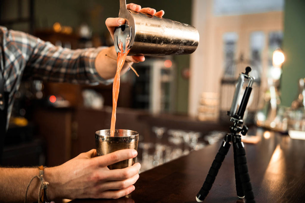 Primer plano del camarero vertiendo cóctel de coctelera en el bar
 - Foto, Imagen