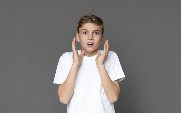 Amazed teen boy looking at camera with distrustful expression - Photo, Image