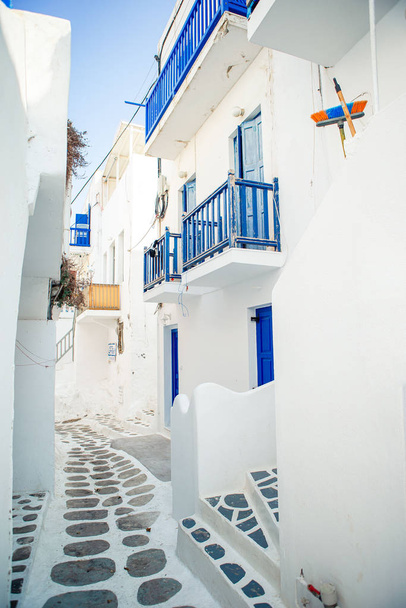 Die engen Gassen der Insel mit blauen Balkonen, Treppen und Blumen in Griechenland. - Foto, Bild