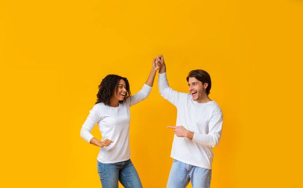 alegre interracial pareja engañando juntos, sosteniendo manos y bailando
 - Foto, imagen