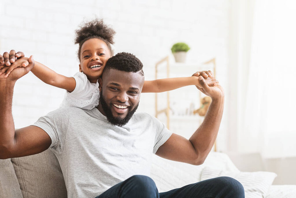 Ihana musta perhe isä ja tytär poseeraa kotona
 - Valokuva, kuva