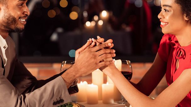 ロマンチックなデートのカップル開催レストランでの笑顔のお座り - 写真・画像