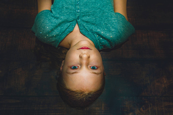 Portrait of a girl on a wooden background, top view. - Fotografie, Obrázek