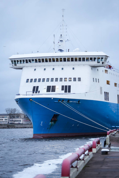 Μεγάλο μπλε φορτηγό πλοίο αγκυροβολημένο σε μικρό βαλτικό θαλάσσιο λιμάνι. - Φωτογραφία, εικόνα