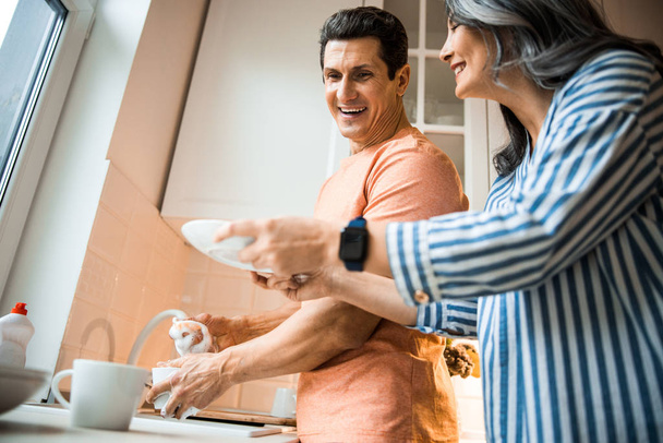 Smiling lady helping for man on the kitchen - Photo, Image