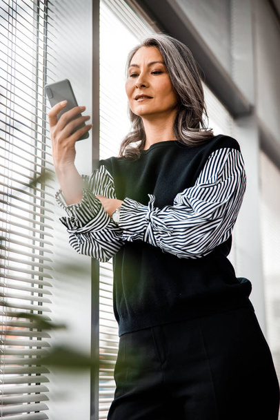 Stylish woman with modern gadget at work stock photo - 写真・画像