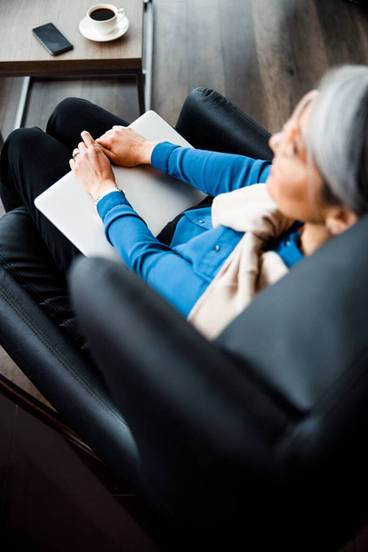 Top view of laptop on the knees of woman stock photo - Foto, afbeelding