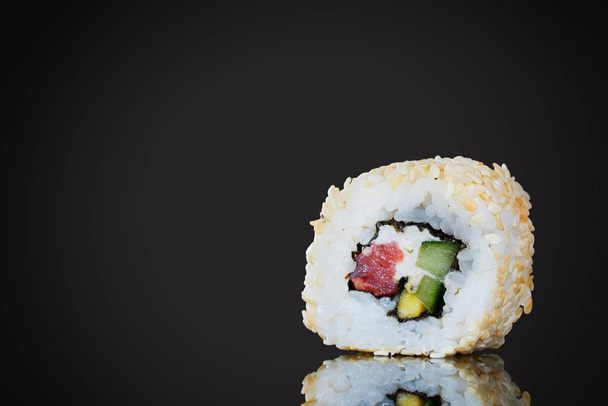 Sushi with red fish and avocado, close-up, on a black background. - Fotoğraf, Görsel
