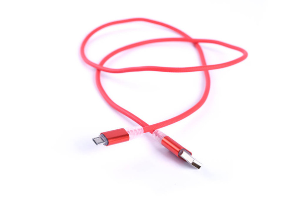 Punainen USB-kaapeli älypuhelimen lataus eristetty valkoisella taustalla
. - Valokuva, kuva
