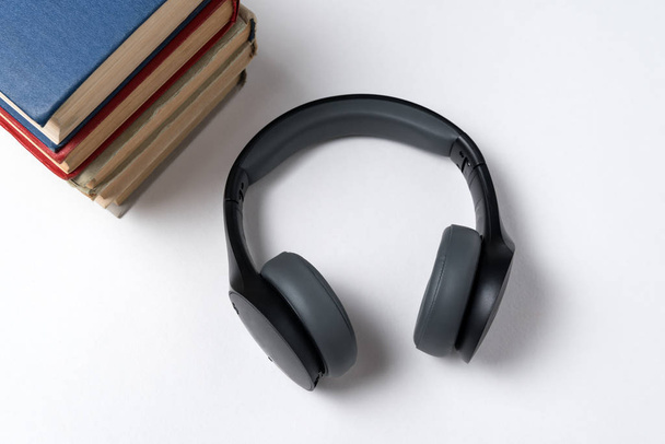 Boeken en koptelefoons op een witte achtergrond. Lezen en muziek concept. - Foto, afbeelding
