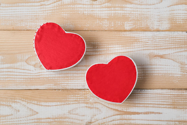 Twee rode hartvormige doosjes op de houten achtergrond. Direct boven. Valentijnsdag - Foto, afbeelding