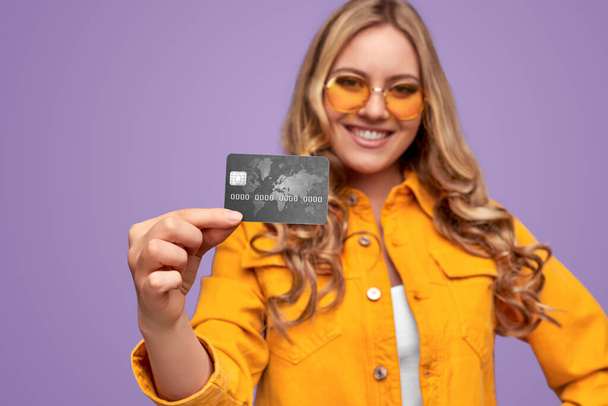 Positive trendy woman showing credit card - Foto, Bild