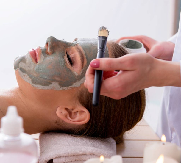 Young woman in spa health concept with face mask - Foto, Imagen