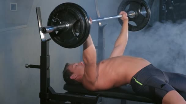 Professional muscular athletic man bodybuilder doing barbell exercise on bench. - Felvétel, videó