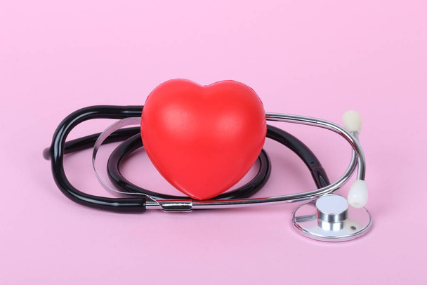 Stethoskop und Herz isoliert auf rosa Hintergrund - Foto, Bild