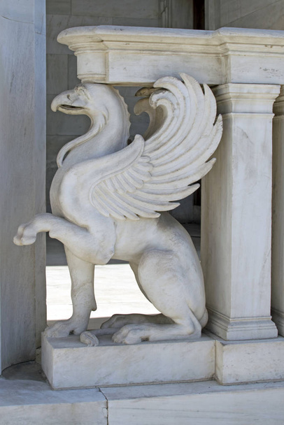 Griffin egy régi görögországi épület díszítő eleme. Fehér márvány griff. Mitikus karakterek az építészetben. - Fotó, kép