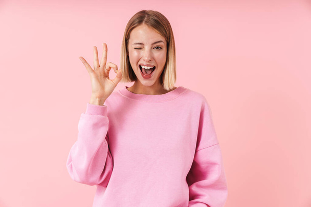 Portrait of beautiful woman smiling and showing ok sign with fingers - Photo, Image