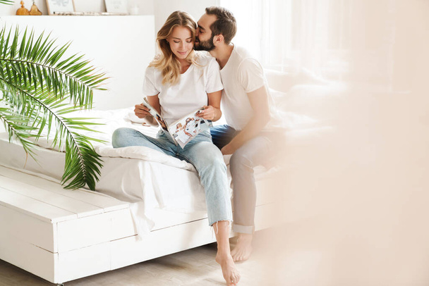 Happy young couple in love relaxing on a couch at the living room - Foto, imagen