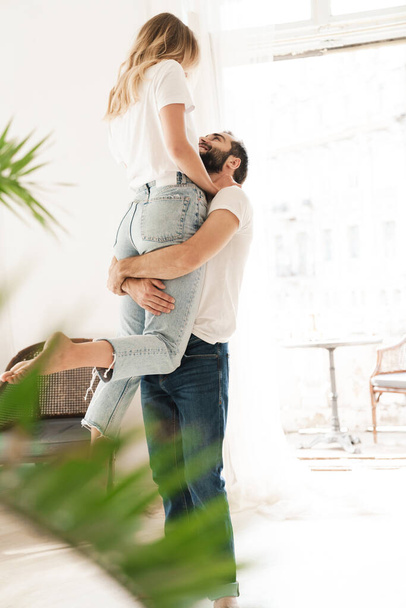 Beautiful happy young couple in love embracing at home - 写真・画像