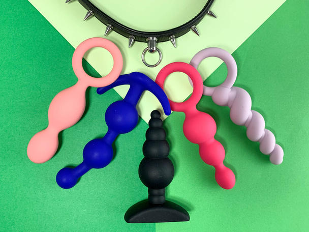 Sexspielzeug. fünf Utplags und Kragen auf grünem Hintergrund .  - Foto, Bild