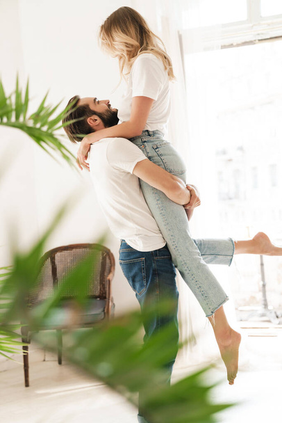 Beautiful happy young couple in love embracing at home - Foto, afbeelding