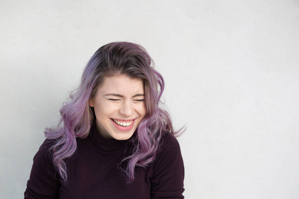 Смеющаяся молодая женщина на сером фоне
 - Фото, изображение