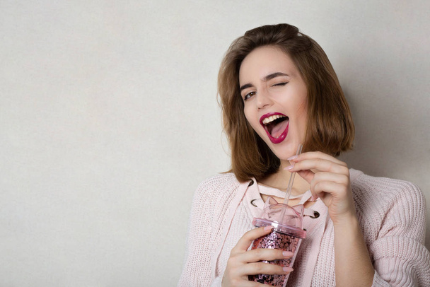 Winking girl holding glass of juice  - Photo, Image