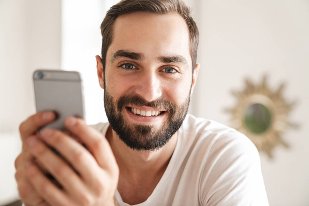 Close up of a smiling young bearded man - Fotó, kép