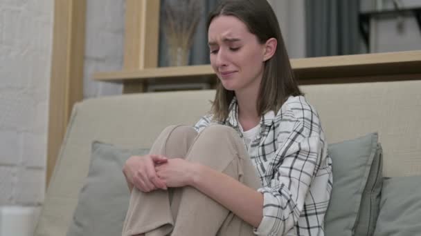 Sad Young Woman Sitting on Sofa and Crying  - Materiał filmowy, wideo