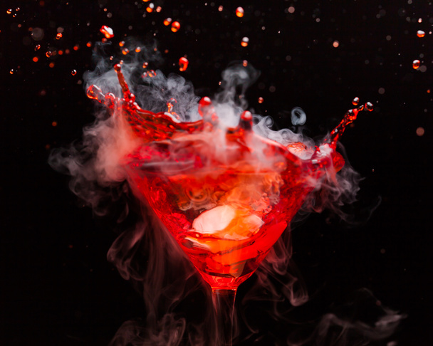 cocktail rouge avec éclaboussures et vapeur de glace
 - Photo, image