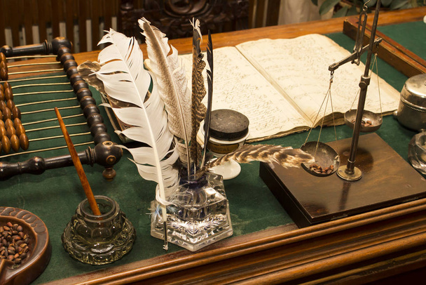Egy antik íróasztal íróeszközökkel, mérlegekkel és fából készült számlákkal - Fotó, kép