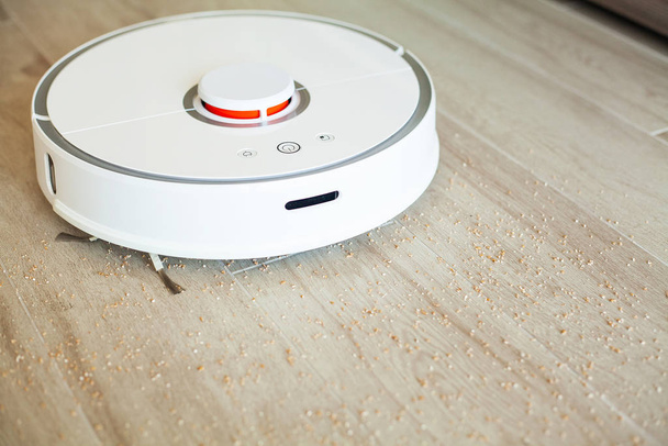 Aspirapolvere robot esegue la pulizia automatica dell'appartamento in un certo momento. Casa intelligente - Foto, immagini