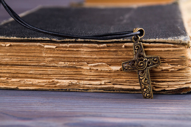 Closeup van christelijk kruis met op de heilige Bijbel met een zwarte omslag. - Foto, afbeelding