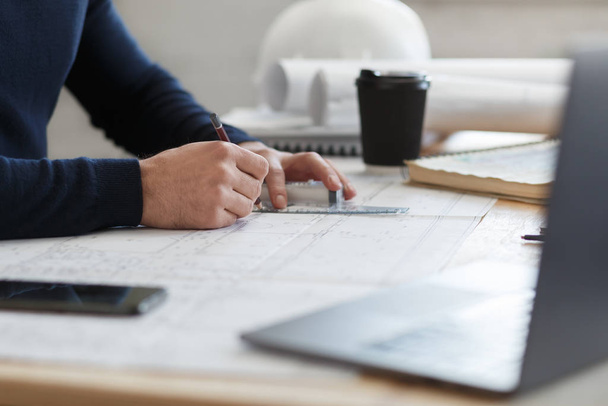 Architect working in office with blueprints.Engineer inspect architectural plan, sketching a construction project.Portrait of handsome bearded man sitting at workplace. Business construction concept - Photo, image