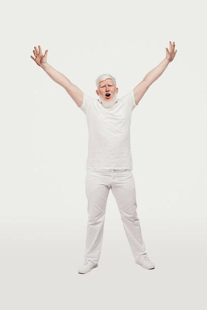 Albino guy celebrating success with raised arms - Zdjęcie, obraz
