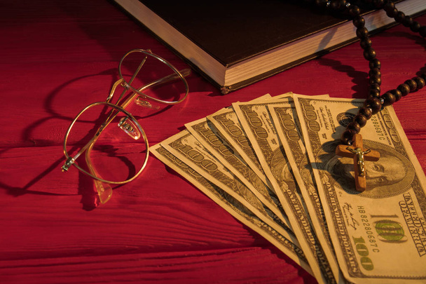 Rosary beads, money, glasses and holy bible. - Foto, Imagen