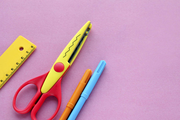 scissors, ruler and crayons on a pink background. Creative, fashionable, minimalistic, school or office workspace with yellow supplies for handycraft on cyan background. Flat lay. - Photo, Image